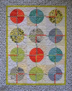 a quilted wall hanging with circles on it