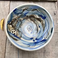 a blue and white bowl sitting on top of a wooden table next to a banana