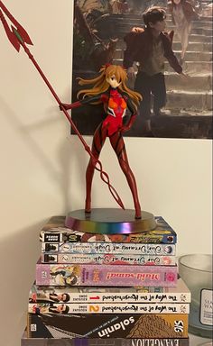 there is a statue on top of books with a red arrow in the shape of a girl