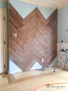 an empty room with hard wood flooring and a large chevron pattern on the wall