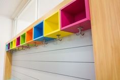 the colorful shelfs have hooks on them