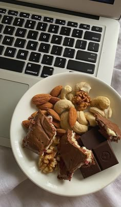 a white plate topped with lots of food next to a laptop