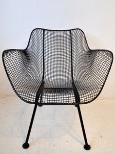 a black wire chair sitting on top of a white floor