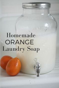 homemade orange laundry soap in a glass jar next to two tangerines