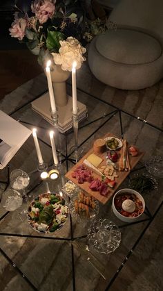 a glass table topped with food and candles