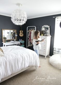 a woman standing in front of a white bed