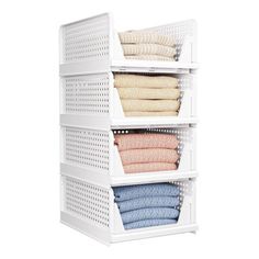 an organized closet with folded towels and blankets in white plastic bins on the bottom shelf