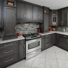 a kitchen with gray cabinets and stainless steel stove top oven in the center, surrounded by tile flooring