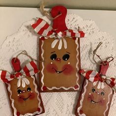 three gingerbread bags with faces on them sitting on a doily covered tablecloth