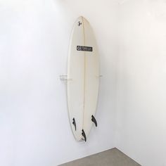 a white surfboard hanging on the wall