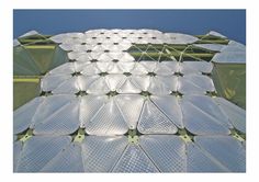 the roof of a building with many white plates on it's sides and some green poles