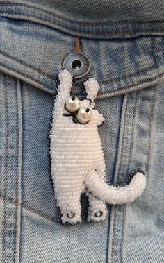 a close up of a button on the back of a pair of blue jeans with a white dog