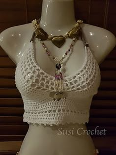 a mannequin wearing a white crochet top and necklace