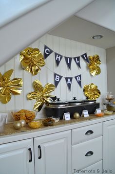 a buffet with gold and black decorations on the wall, along with bunting flags