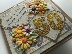 a close up of a birthday card with buttons and flowers on the number fifty six