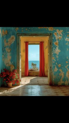 an open door leading to the ocean from a room with blue walls and red curtains