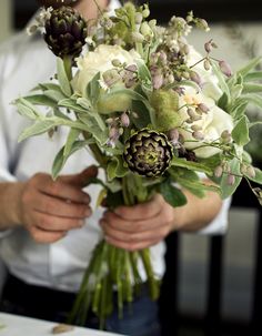 a man holding a bouquet of flowers in his hands