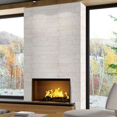 a living room filled with furniture and a fire place in front of a window covered in snow