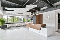 an office lobby with white walls and wood accents on the ceiling, along with modern furniture