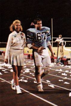 two people are running on a track with white flowers all over the ground in front of them