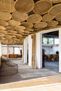 the inside of a building with wicker ceilinging and wooden furniture on it's sides