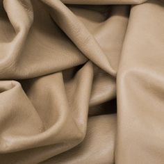 an up close shot of a tan leather fabric with very soft folds and wrinkles