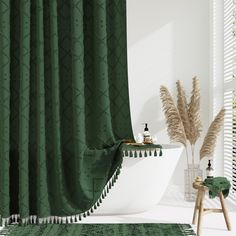 a green shower curtain with tassels on it in a white bathtub next to a potted plant