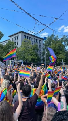 a large group of people holding rainbow flags