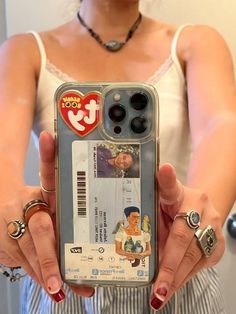 a woman holding up a cell phone case with an image of a man on it