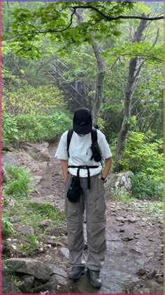 a person with a backpack standing on a trail