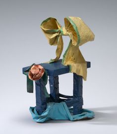 a sculpture with a hat on it's head sitting on top of a chair