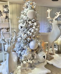 a christmas tree decorated with white and silver ornaments