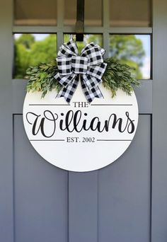 the williams sign is hanging on a door with a bow around it's neck