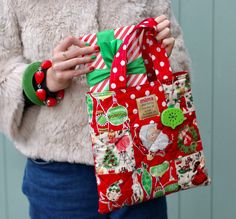 a woman holding a red and green christmas bag