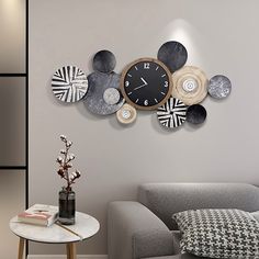 a clock mounted to the side of a wall next to a couch and table in a living room