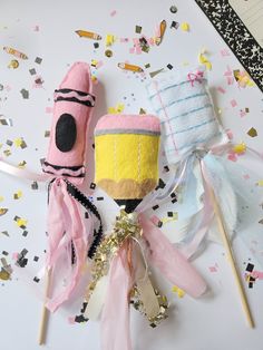 two candy lollipops on top of a table with confetti and streamers