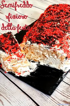 a cake with red and white sprinkles on it sitting on top of a wooden table