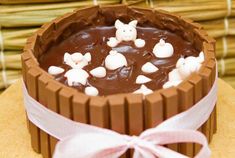 a chocolate cake with marshmallows and bunny decorations on top is sitting on a table