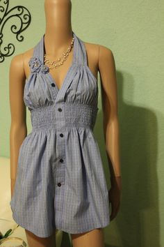 a mannequin wearing a blue and white striped romper with buttons on the front