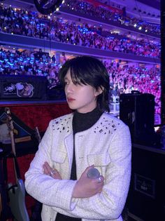 a woman standing in front of a crowd with her arms crossed