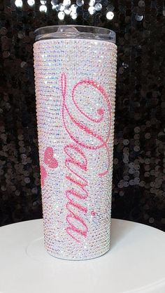 the tumbler cup has been decorated with pink and silver sparkles on it's side