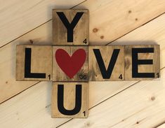 a cross made out of wooden blocks with the words you love on it