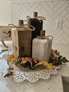 two wooden blocks sitting on top of a plate covered in leaves and acorns