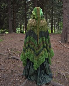 a green and black crocheted shawl in the woods