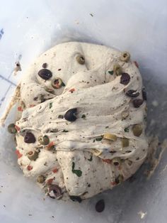 an uncooked pita bread with olives and peppers