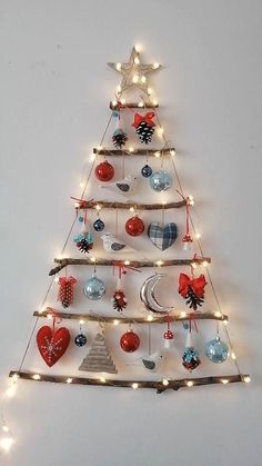 a christmas tree made out of branches with lights and ornaments hanging from it's sides