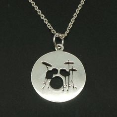 a silver necklace with a drum set on it