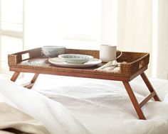 a tray that is on top of a bed with a cup and plate in it