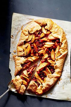 an apple pie is cut into slices on a piece of parchment paper