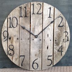 a clock made out of wooden planks with numbers on each side and the hands